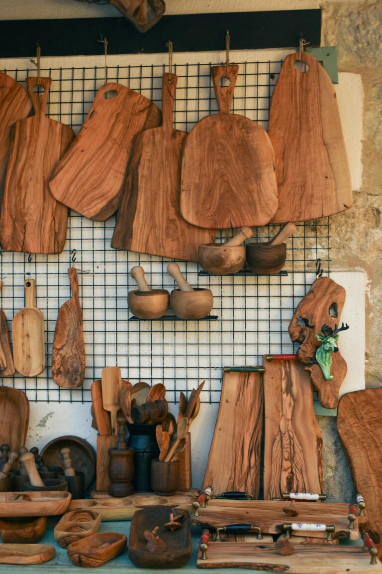 A variety of handcrafted wooden kitchen tools and boards on display in a shop.