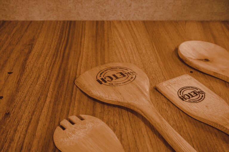 Close-up of wooden kitchen utensils on a rustic wooden surface, perfect for culinary themes.