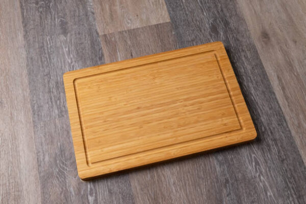 Empty cutting board on a wooden table, close up, copy space for text.